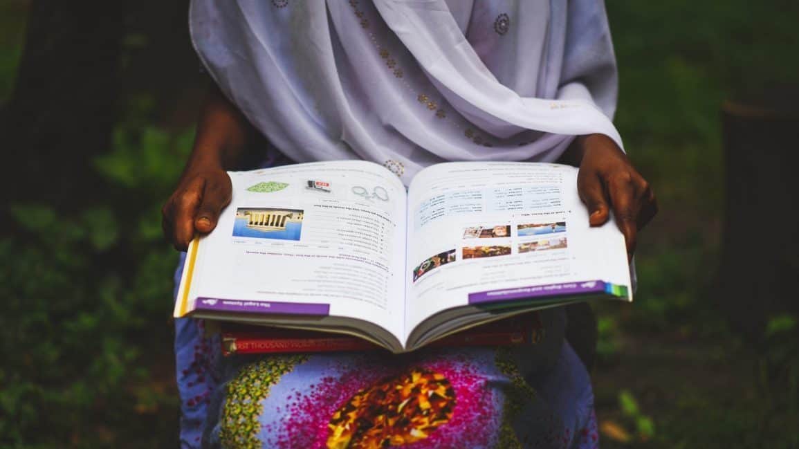 Medina holds open one of her English textbooks. Her family arrived in the U.S. in 2018 from East Africa. 