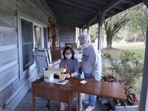 Melissa sews with her grandmother outside following COVID protocols.