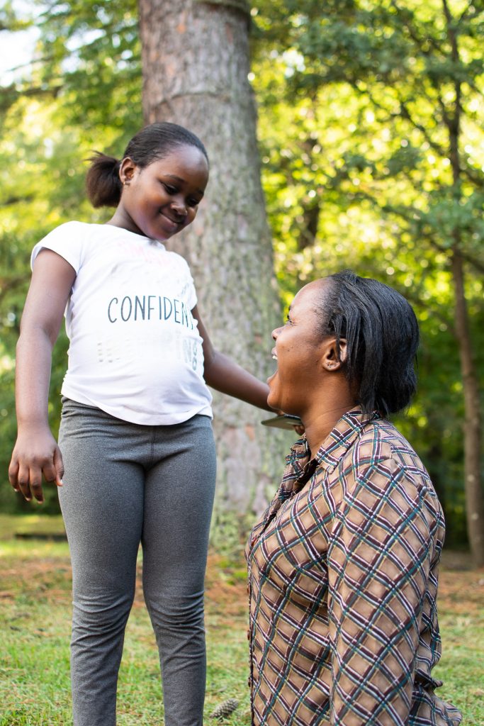 Refugee mother and daughter smile at each other