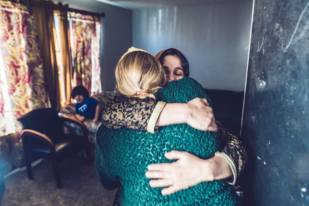 caseworker hugging refugee in north texas apartment