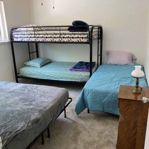 Furnished bedroom with three beds for a refugee family
