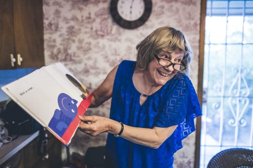 Elderly woman reading book.