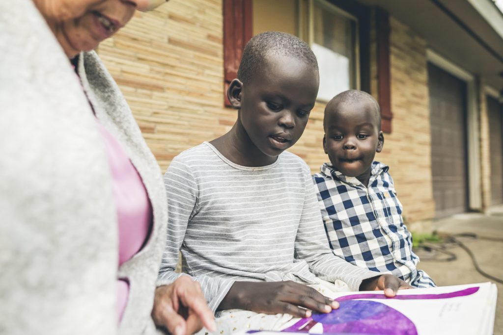 Child reading book with older woman.