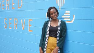 Woman standing in front of a mural.