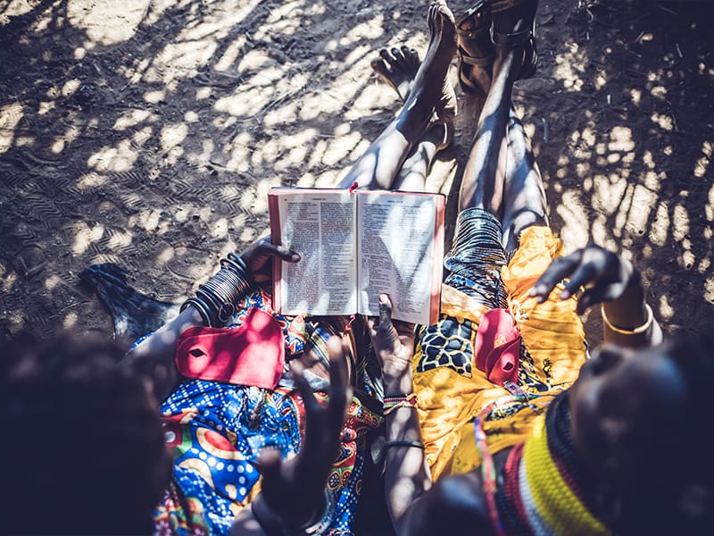 Two women in Turkana, Kenya study scripture together. 