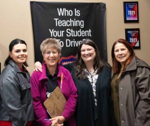 Rita stands with the women who are helping refugees learn to drive.