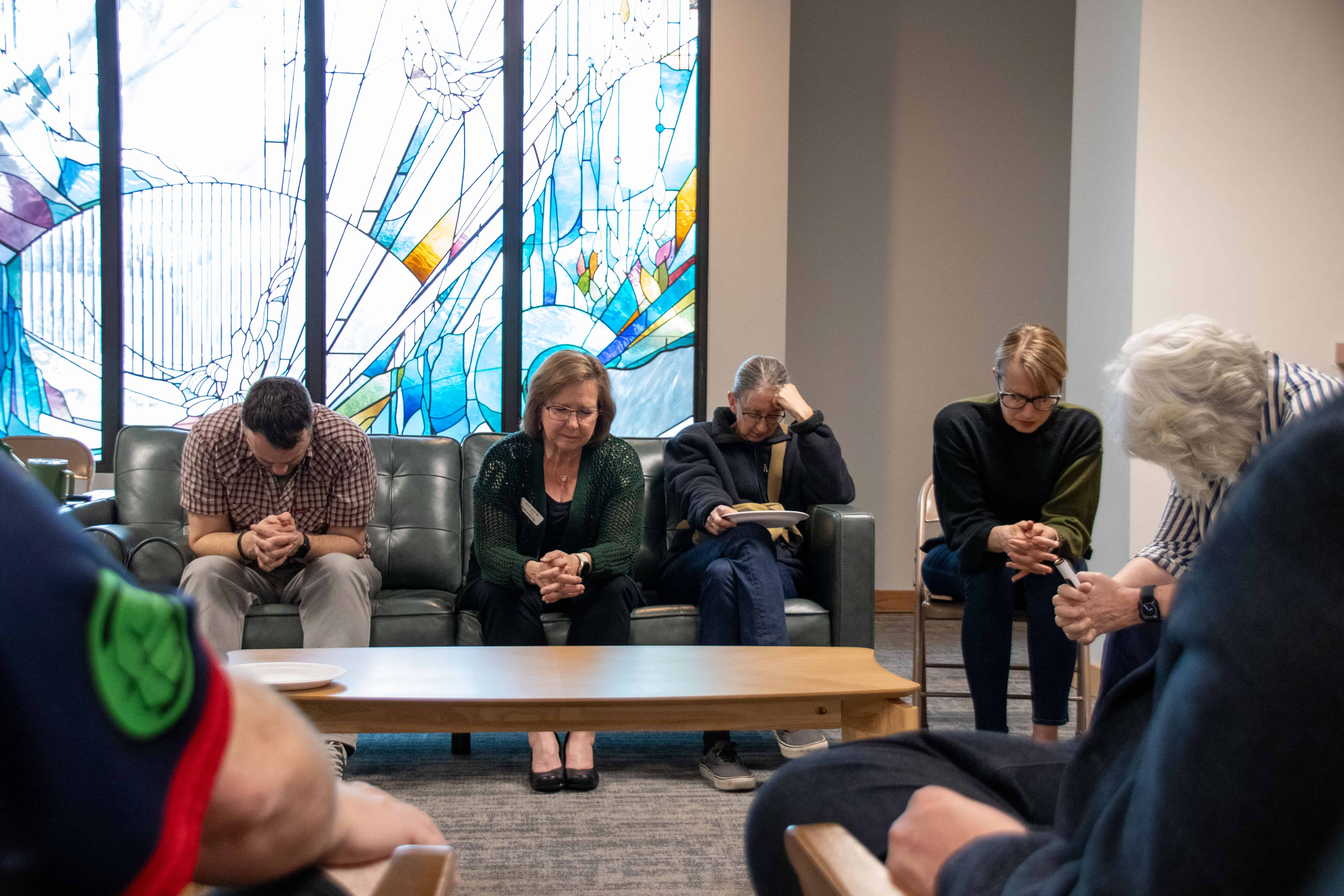 A group of people in prayer for refugees.