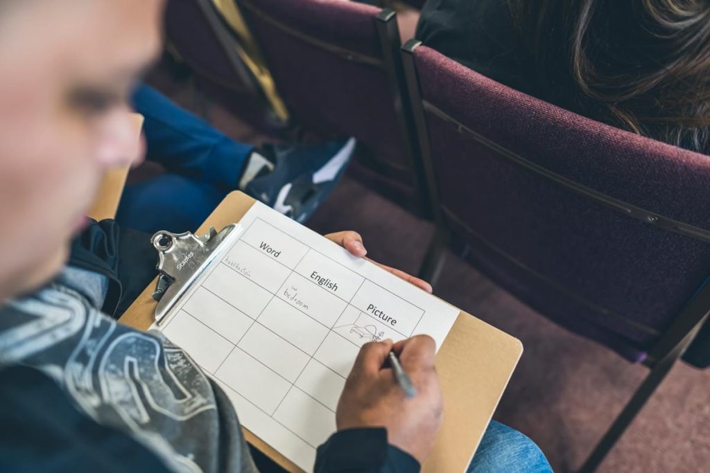 Seated World Relief Spokane client takes notes during extended case management support.