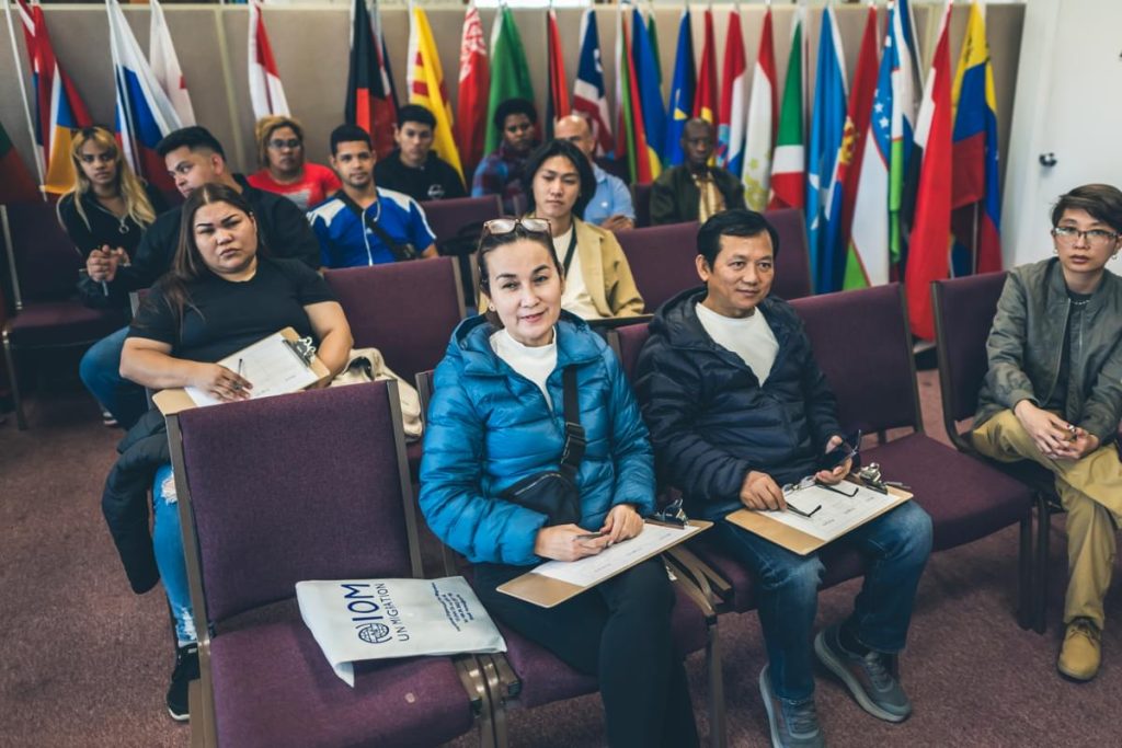 New refugees sit in World Relief classroom with extended services paperwork.