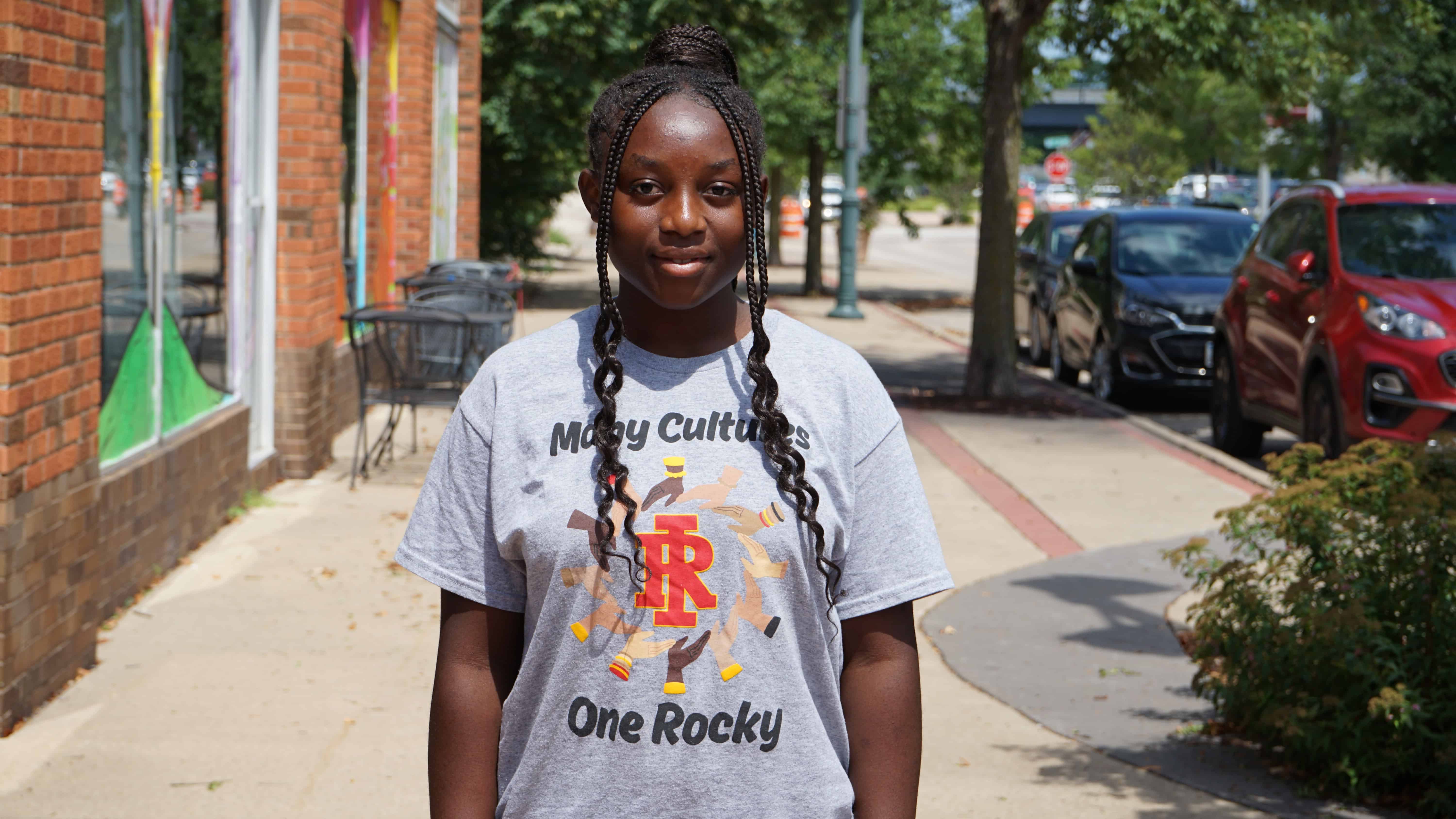 A high school student standing on the sidewalk