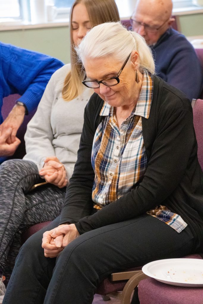 Church member praying for immigrants with a smile.