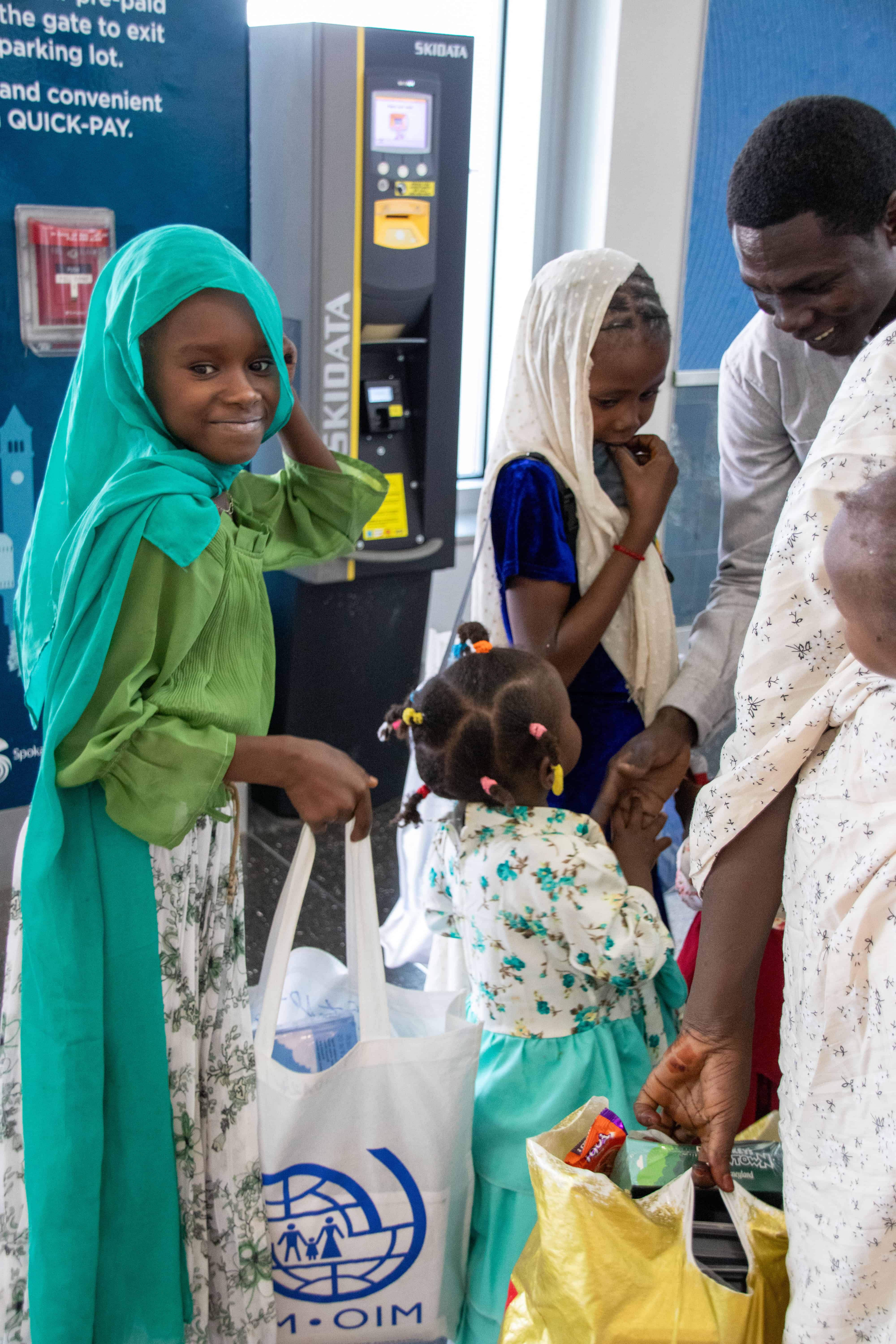 A refugee child smiles at the airport. She had a good first experience.