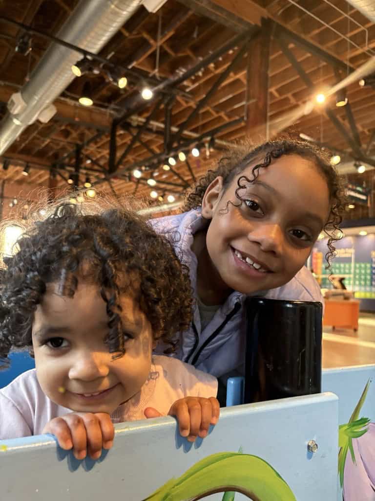 Evany's daughters smile while playing. They arrived legally last year as immigrants in America.