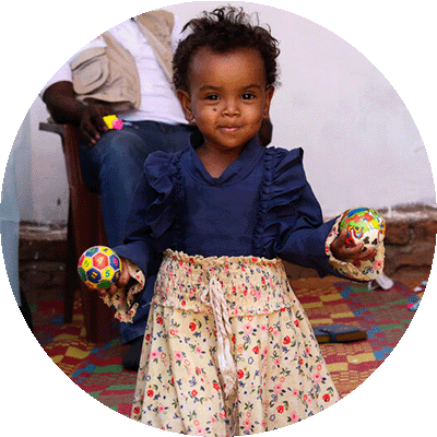 gift-guide-ip-early-childhood-development small child holding toy balls