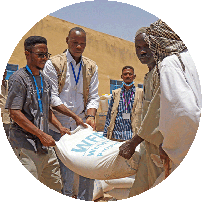 gift-guide-ip-food-assistance two people giving a bag of supplies to a couple