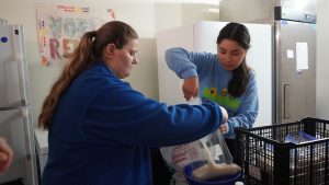 Two people bagging rice