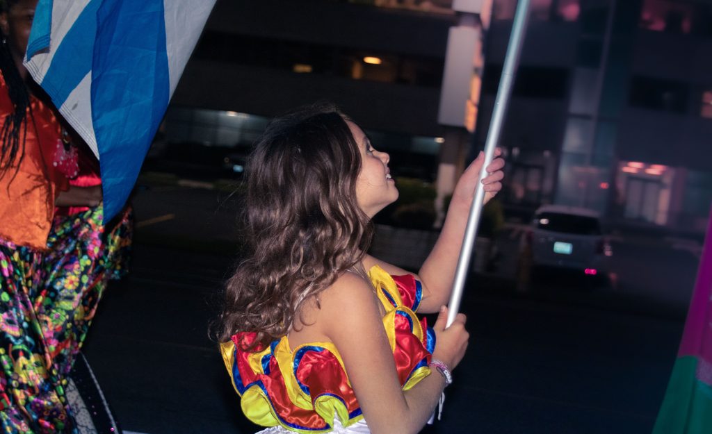 Young girl carries Venezuelan flag.