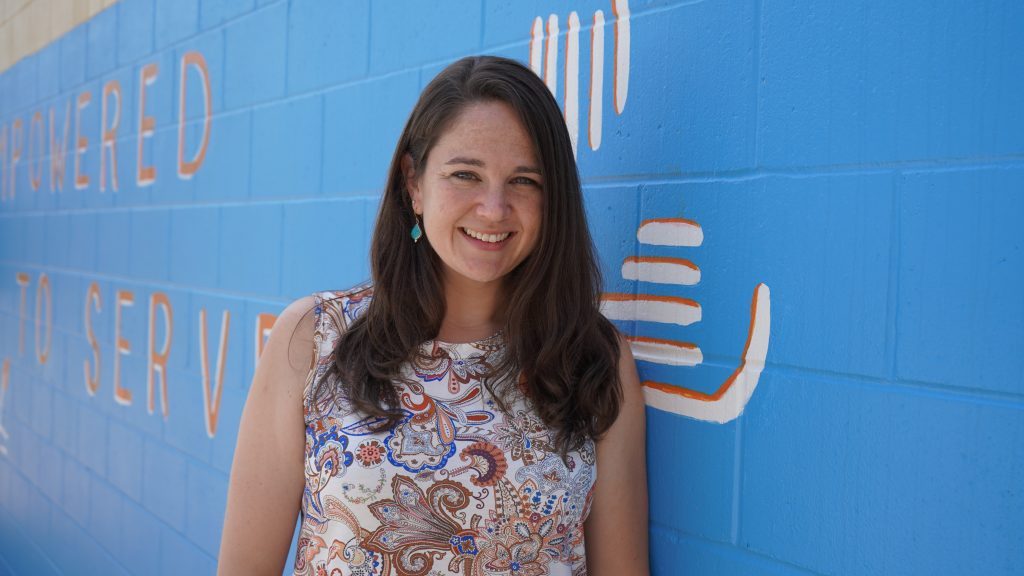 a woman standing in front of a wall.