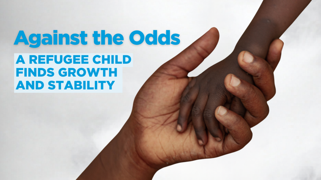 the hand of a refugee child resettled by world relief holds the hand of an adult