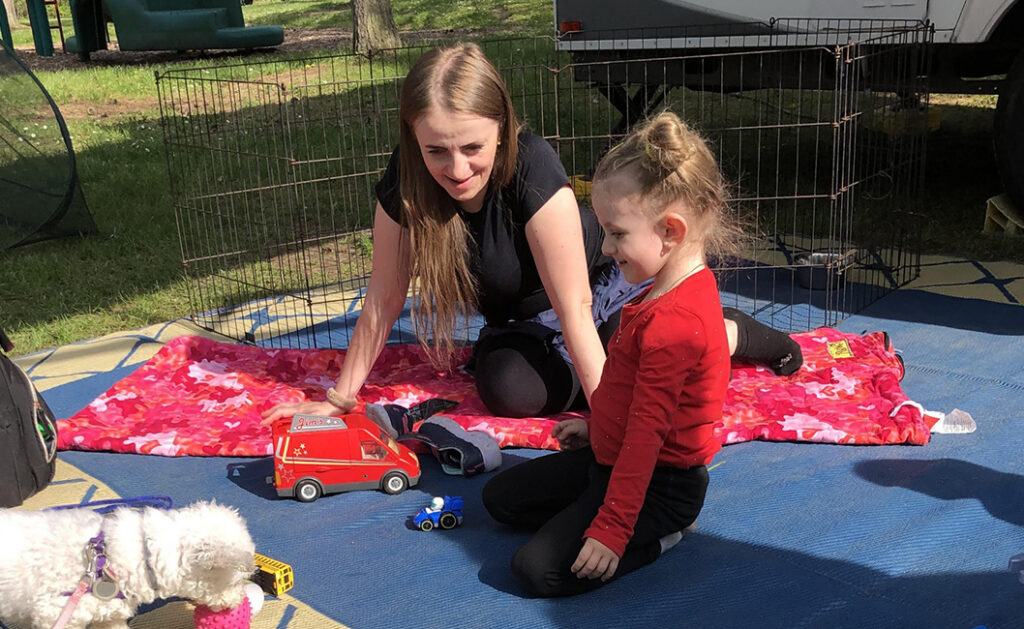 Vasylyna and her daughter play at the Roger's campsite. Every day, volunteers help Ukrainians feel welcome.