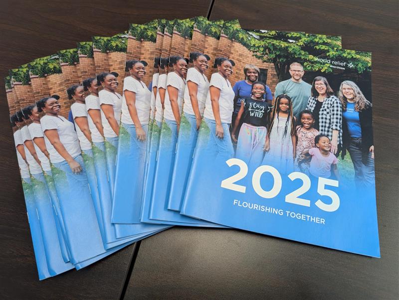 World Relief Wisconsin 2025 annual report covers spread on a desk.