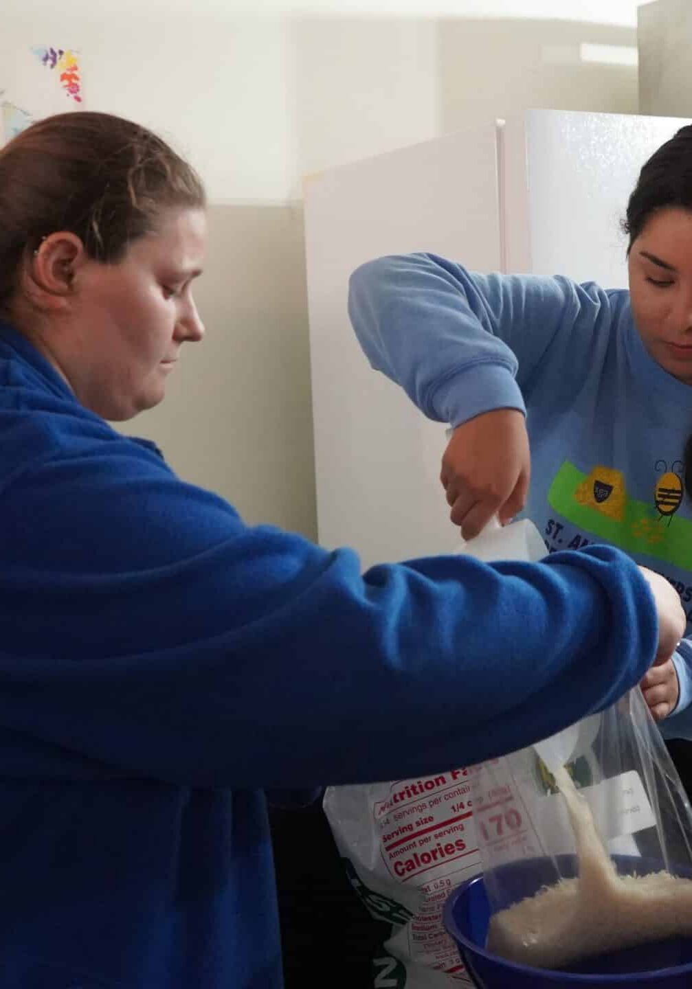 Two people bagging rice