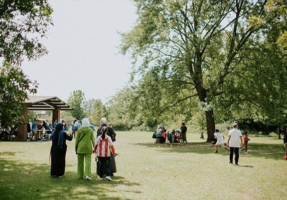Families walk to a picnic pavilion at a World Relief event